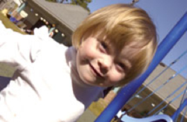 Smiling young girl beside swing set