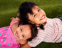 girl and boy playing on the grass